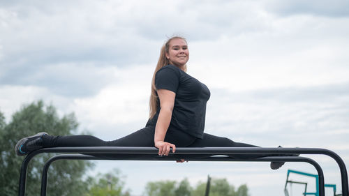 Woman with legs apart on parallel bars