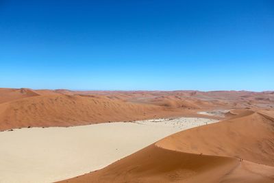 Scenic view of desert against clear blue sky