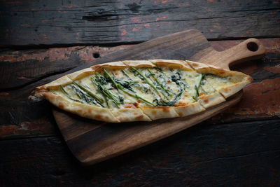 High angle view of pizza on cutting board