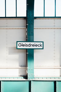 Low angle view of road sign against blue sky