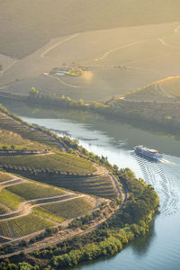 High angle view of agricultural field by river against sky