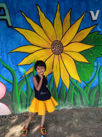 Portrait of smiling woman standing against wall