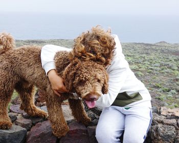 Rear view of woman with dog against sky