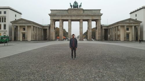 Full length of man standing against brandenburg gate