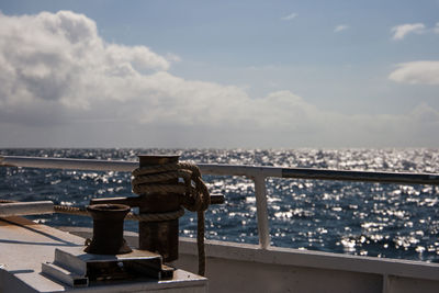 Close-up of railing against sea and cityscape