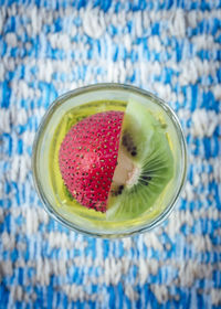 Directly above of kiwi and strawberry drink in glass on table