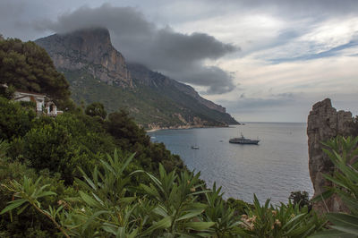 Scenic view of yacht, sea and mountains against sky