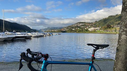 People on sea by mountains against sky