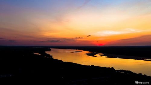 Scenic view of calm sea against dramatic sky during sunset