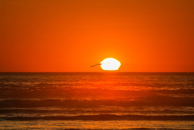 Scenic view of sea against orange sky