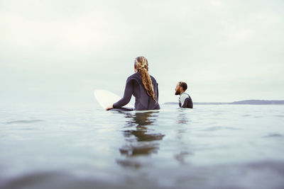 People enjoying in sea against sky