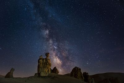 Low angle view of rock formation against sky at night