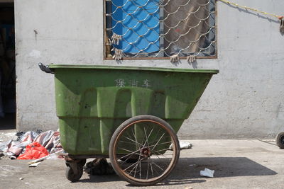 Garbage cart against house on sunny day