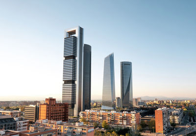 Modern buildings in city against clear sky