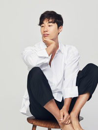 Young man looking away against white background