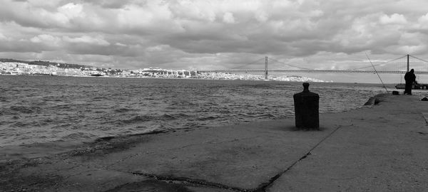 April 25th bridge over tagus river against cloudy sky