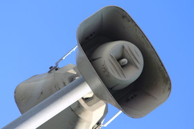 Low angle view of megaphones against blue sky