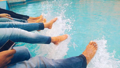 People sitting by swimming pool
