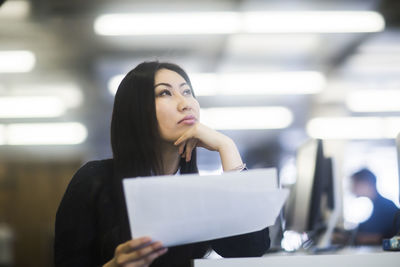 Young asia woman with paper in an office watching