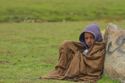 Portrait of young woman sitting on field