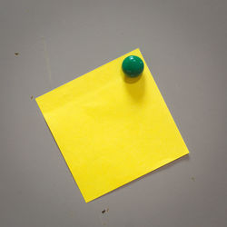 Close-up of yellow paper on table