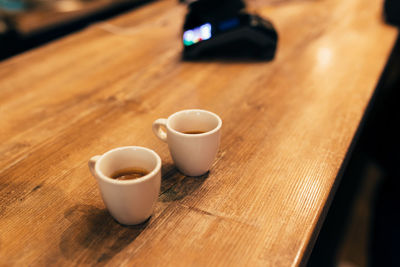 Two cups of espresso coffee at table in cafe, bank terminal. blurred background. high quality photo