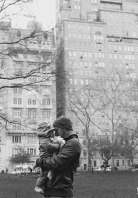 Father carrying son while standing outdoors in winter