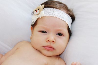 Portrait of cute baby lying on bed