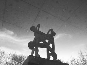 Low angle view of sculpture against cloudy sky