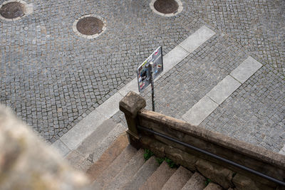 Top view of the street with paving stones, stone stairs and road sign. urban background