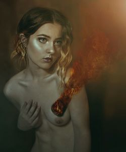 Digital composite image of fire emitting from woman breast