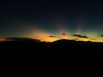 Scenic view of silhouette mountains against sky at sunset