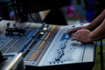 Cropped hands of man playing sound mixer