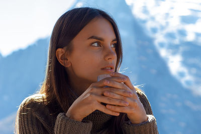 Girl drinks tea against the backdrop of mountains