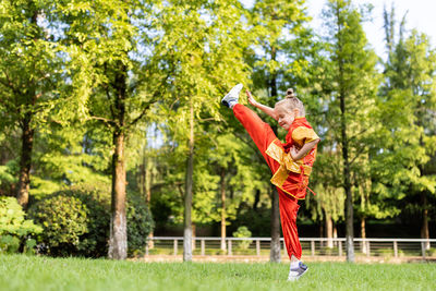 Full length of woman exercising on field