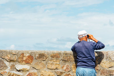 Rear view of man standing against wall