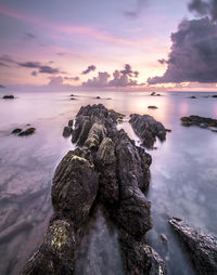 Rock formations in sea at dusk