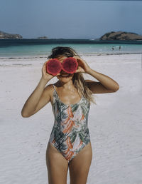 Midsection of woman standing at beach against sky