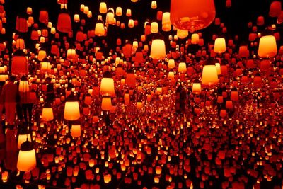 Illuminated lanterns hanging in row at night