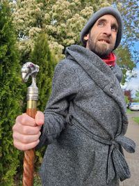 Portrait of man holding umbrella while standing outdoors