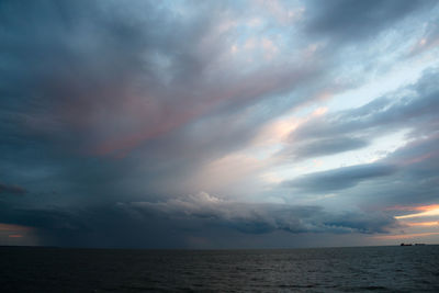 Scenic view of sea against cloudy sky during sunset