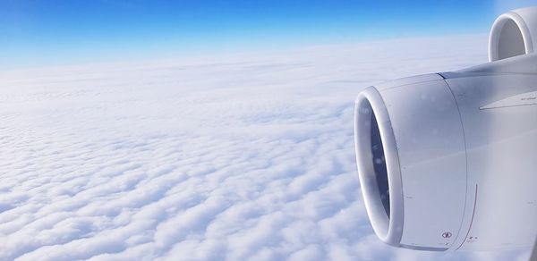 Airplane flying over cloudscape against sky