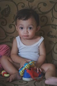 Cute baby boy sitting with toy