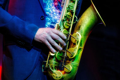 Midsection of man playing guitar at music concert