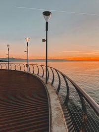 A pier with street lights at the sunset. sea and mountains view