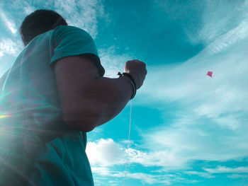 Low angle view of man flying against sky