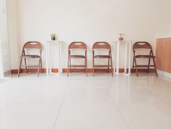 Empty chairs and tables against wall at home