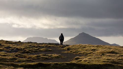 Man standing on field against sky