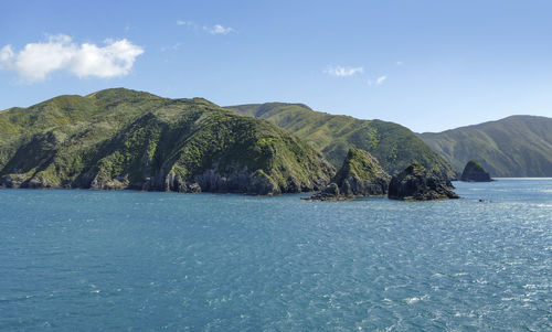 Scenic view of sea and mountains against sky