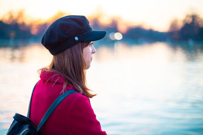 Side view portrait of young woman in lake during sunset